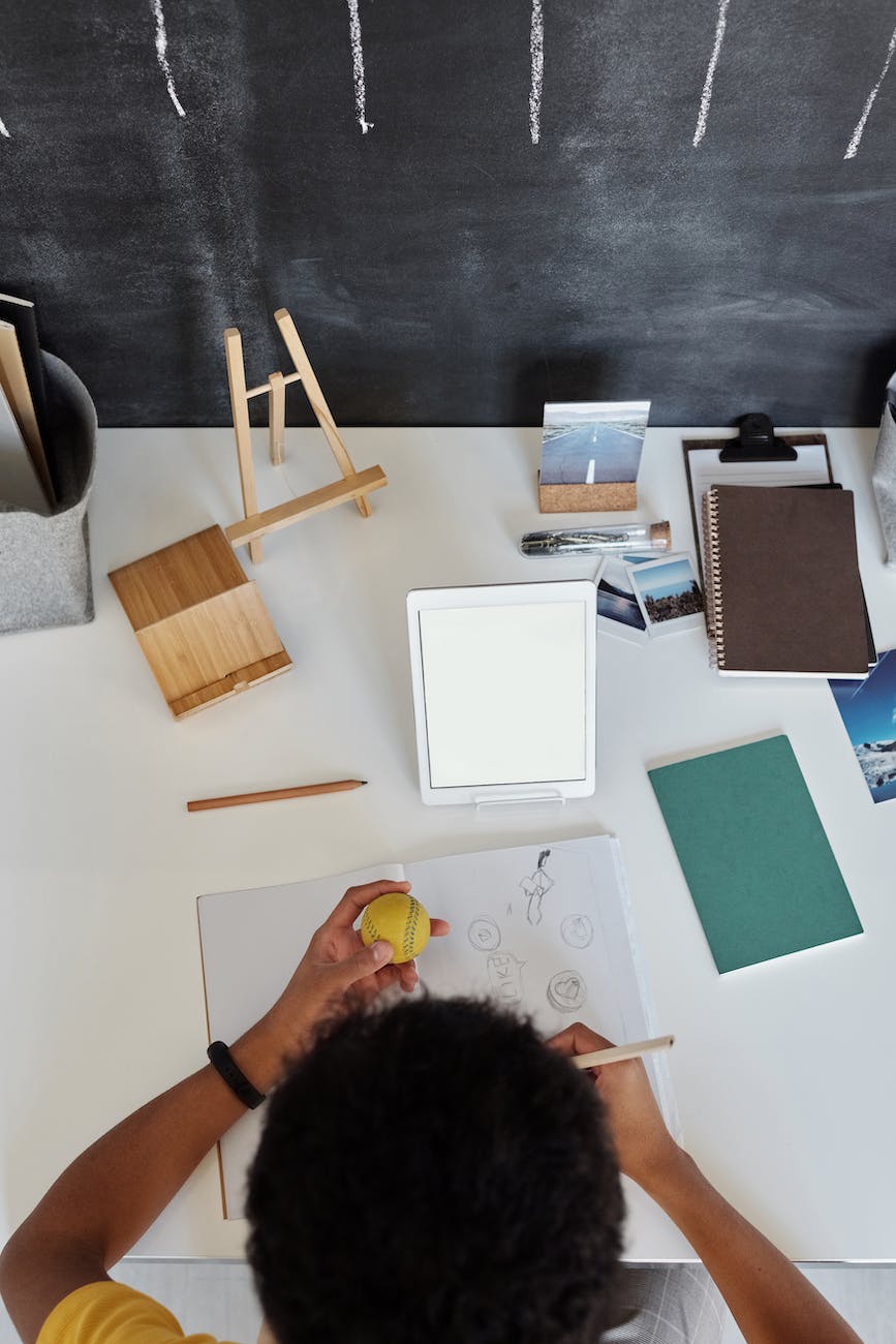 top view photo of boy drawing on white paper