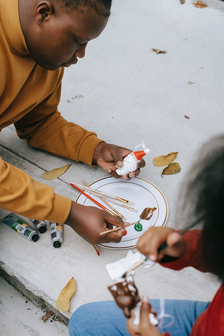 black teen man mixing paint for decorating figures